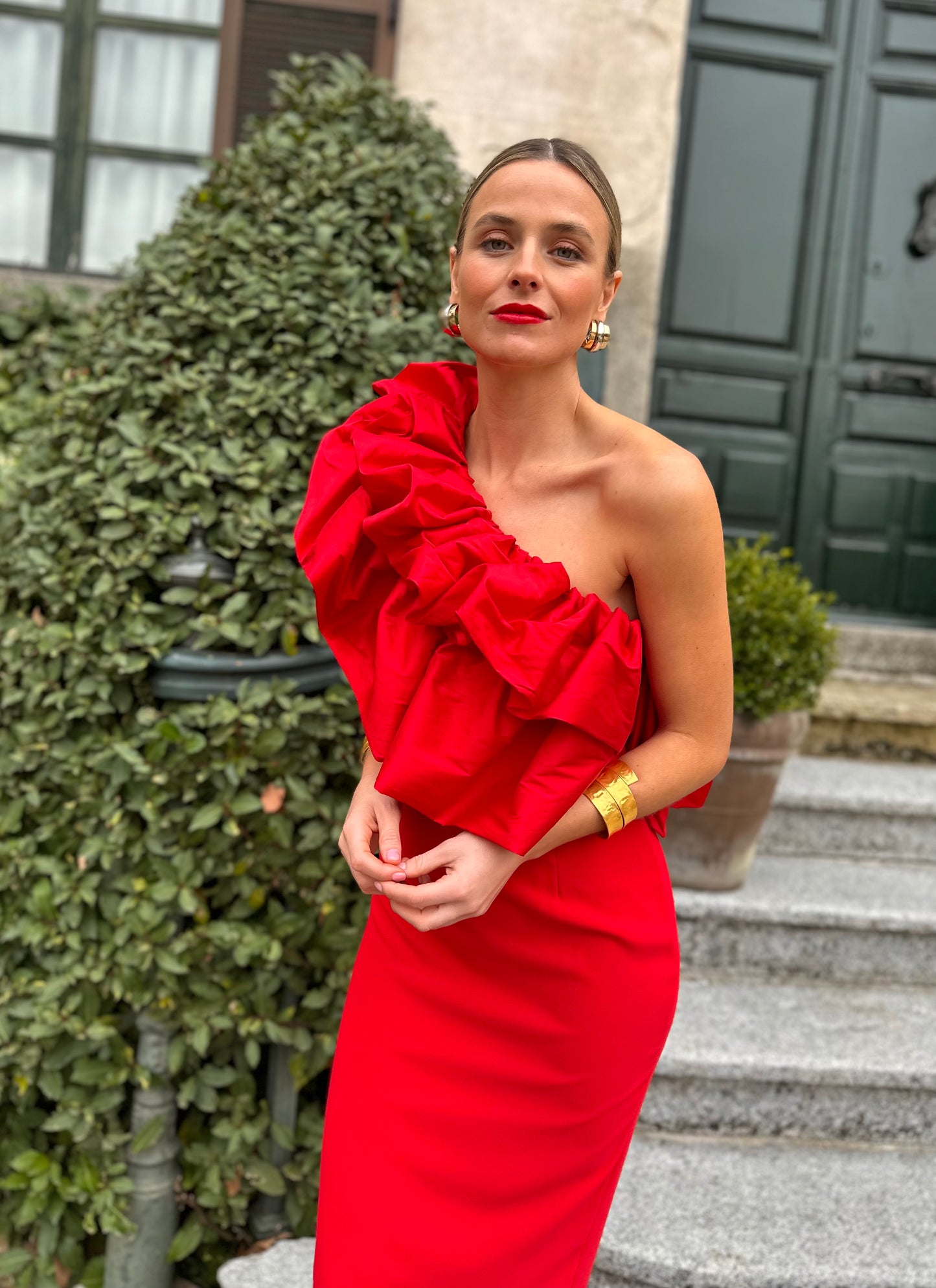 Vestido de Fiesta largo midi, confeccionado en crepe rojo, escote asimétrico con doble gran volante de tafeta en rojo. Abertura trasera en la falda.