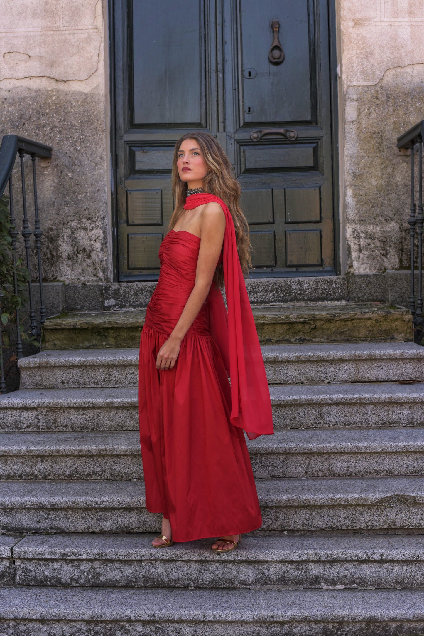 El Vestido Lady Pantera rojo es una elección atrevida y elegante para invitadas que buscan un look con presencia y movimiento. Diseñado con un escote palabra de honor y un cuerpo muy fruncido que realza el busto y la figura, este vestido largo de fiesta destaca por su falda abullonada desde la cadera, que aporta volumen y dramatismo con cada paso.
Confeccionado en tafeta de alta calidad en un impactante tono cardenal, incluye un fular de gasa a juego, perfecto para cubrir los hombros con ligereza o jugar c