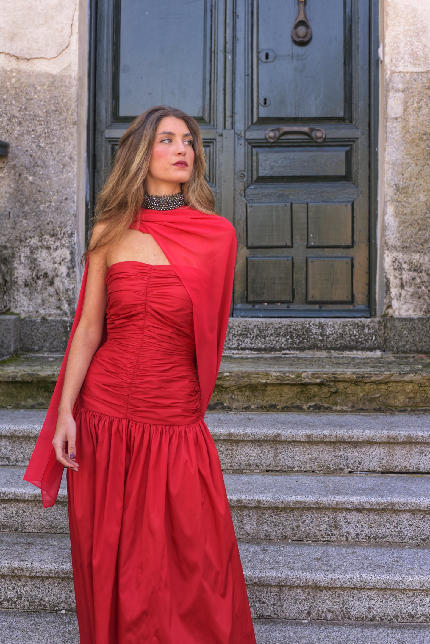 El Vestido Lady Pantera rojo es una elección atrevida y elegante para invitadas que buscan un look con presencia y movimiento. Diseñado con un escote palabra de honor y un cuerpo muy fruncido que realza el busto y la figura, este vestido largo de fiesta destaca por su falda abullonada desde la cadera, que aporta volumen y dramatismo con cada paso.
Confeccionado en tafeta de alta calidad en un impactante tono cardenal, incluye un fular de gasa a juego, perfecto para cubrir los hombros con ligereza o jugar c