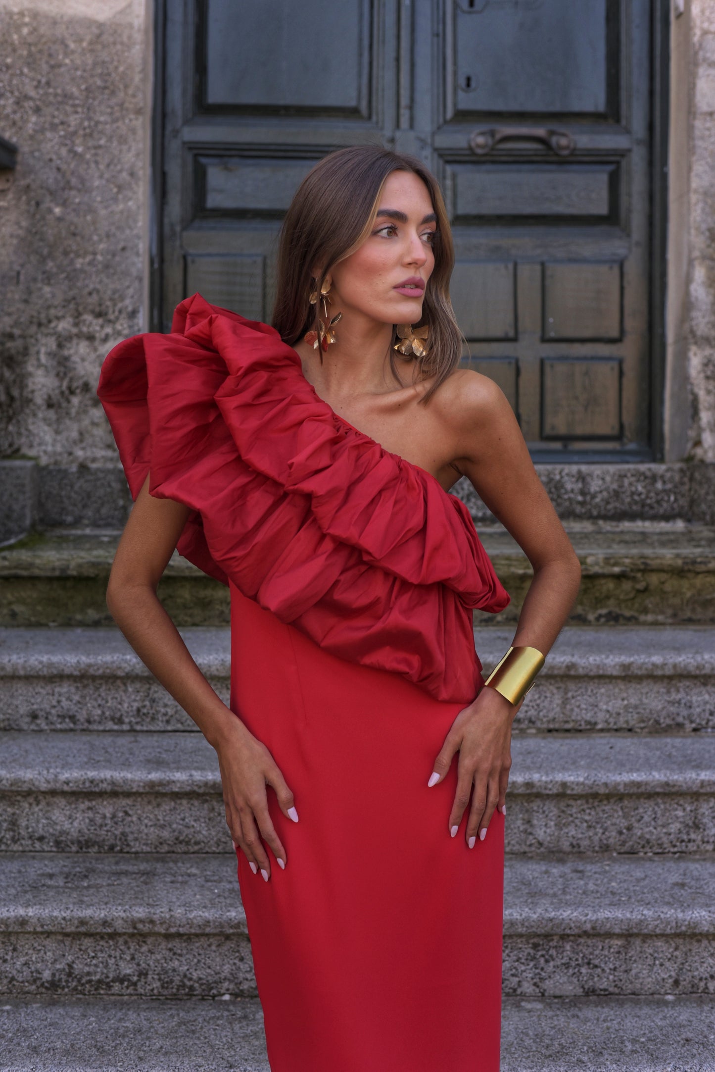 Vestido de Fiesta largo midi, confeccionado en crepe rojo, escote asimétrico con doble gran volante de tafeta en rojo. Abertura trasera en la falda.
