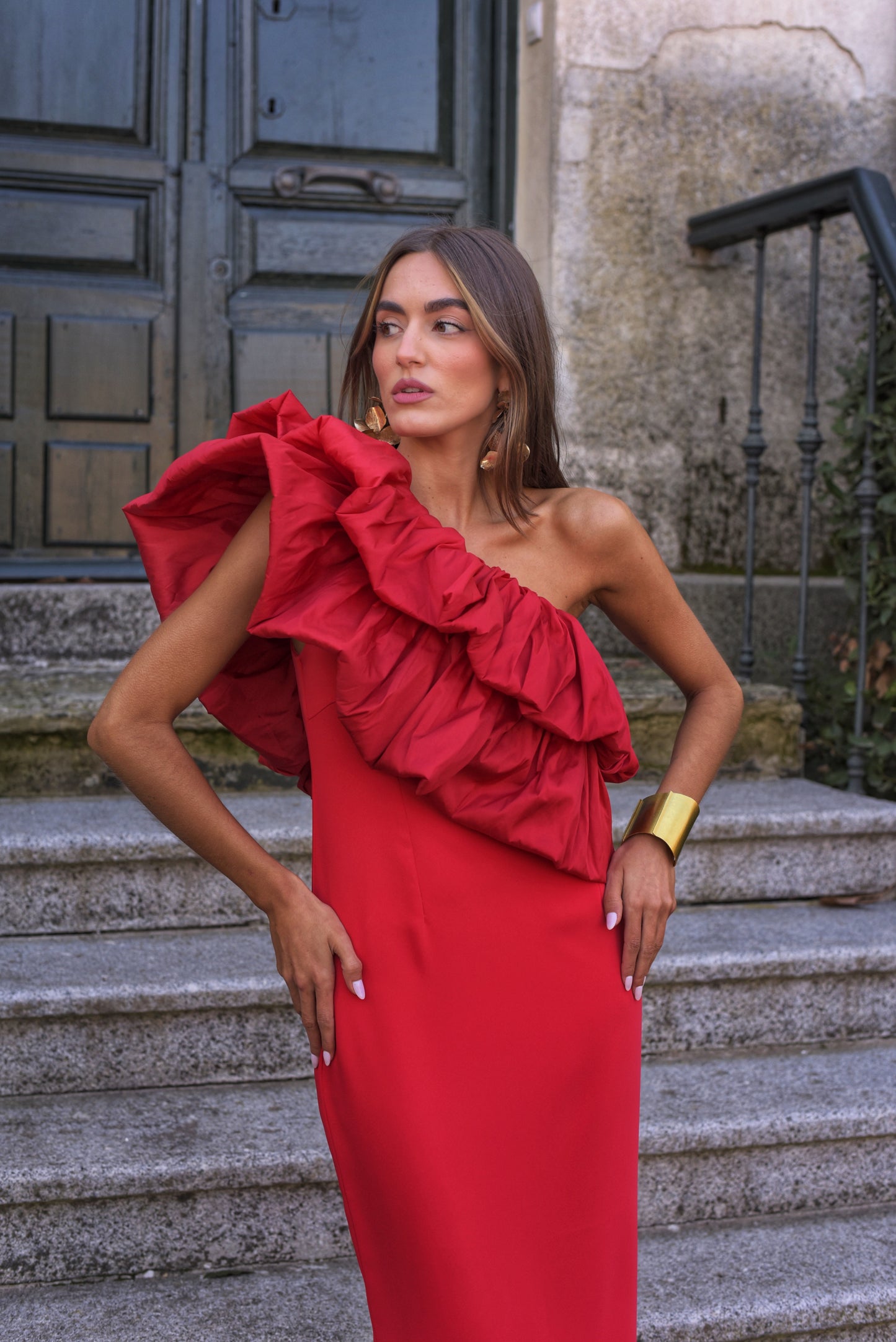 Vestido de Fiesta largo midi, confeccionado en crepe rojo, escote asimétrico con doble gran volante de tafeta en rojo. Abertura trasera en la falda.