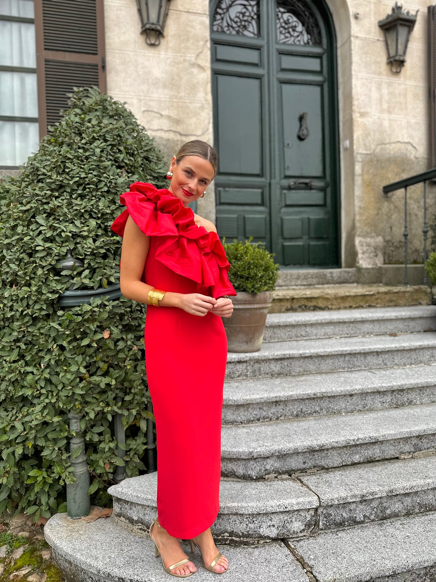 Vestido de Fiesta largo midi, confeccionado en crepe rojo, escote asimétrico con doble gran volante de tafeta en rojo. Abertura trasera en la falda.