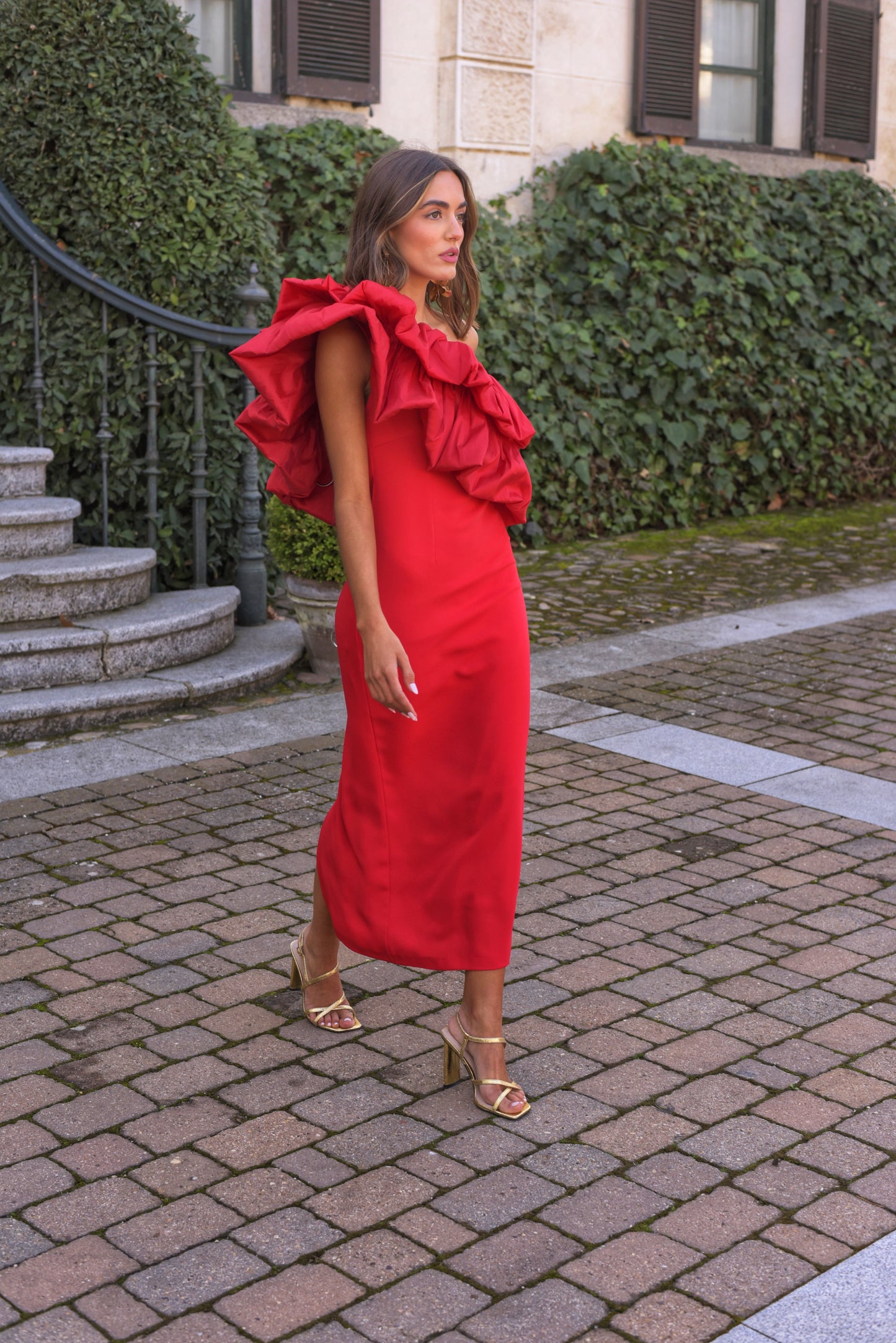 Vestido de Fiesta largo midi, confeccionado en crepe rojo, escote asimétrico con doble gran volante de tafeta en rojo. Abertura trasera en la falda.