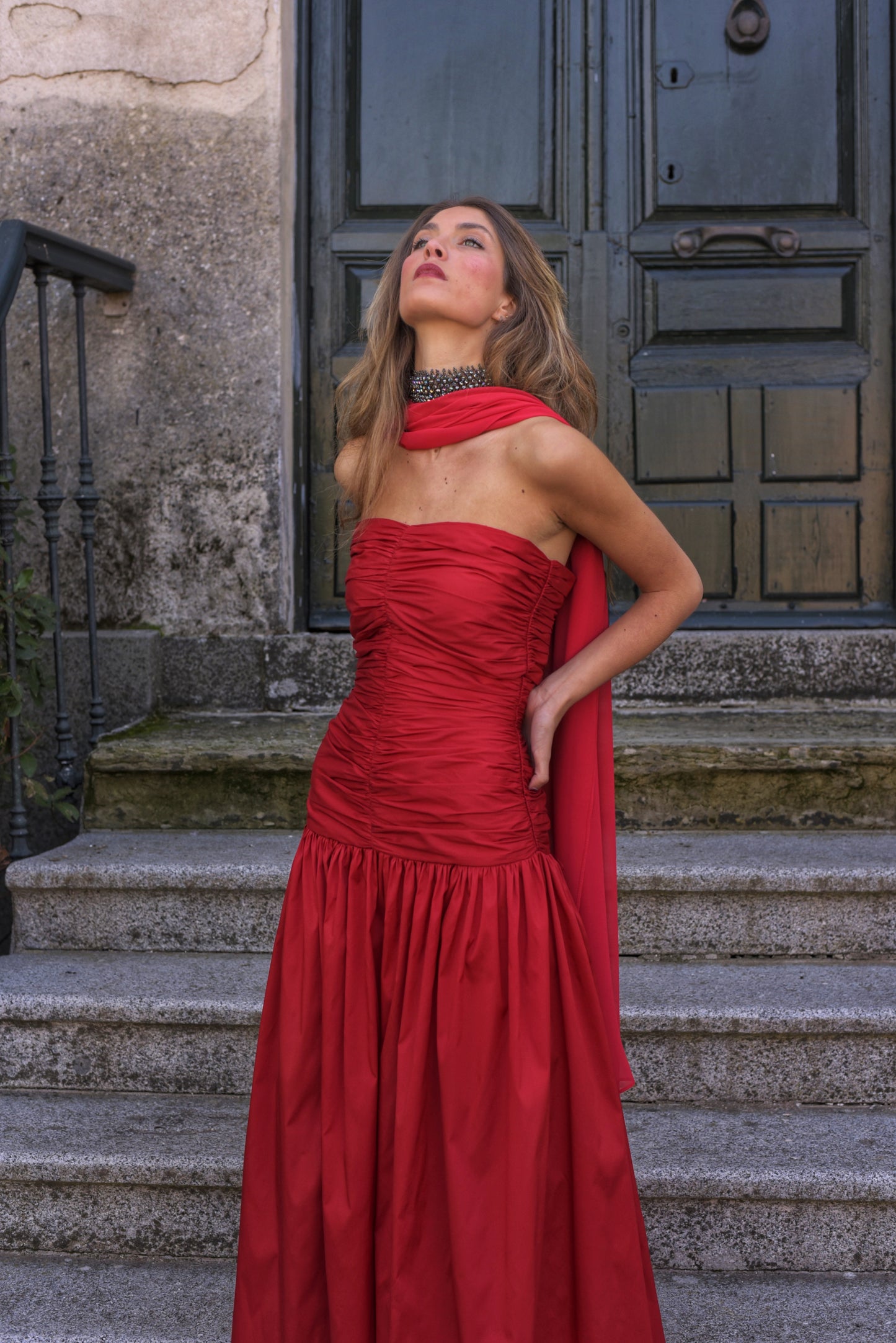 El Vestido Lady Pantera rojo es una elección atrevida y elegante para invitadas que buscan un look con presencia y movimiento. Diseñado con un escote palabra de honor y un cuerpo muy fruncido que realza el busto y la figura, este vestido largo de fiesta destaca por su falda abullonada desde la cadera, que aporta volumen y dramatismo con cada paso.
Confeccionado en tafeta de alta calidad en un impactante tono cardenal, incluye un fular de gasa a juego, perfecto para cubrir los hombros con ligereza o jugar c