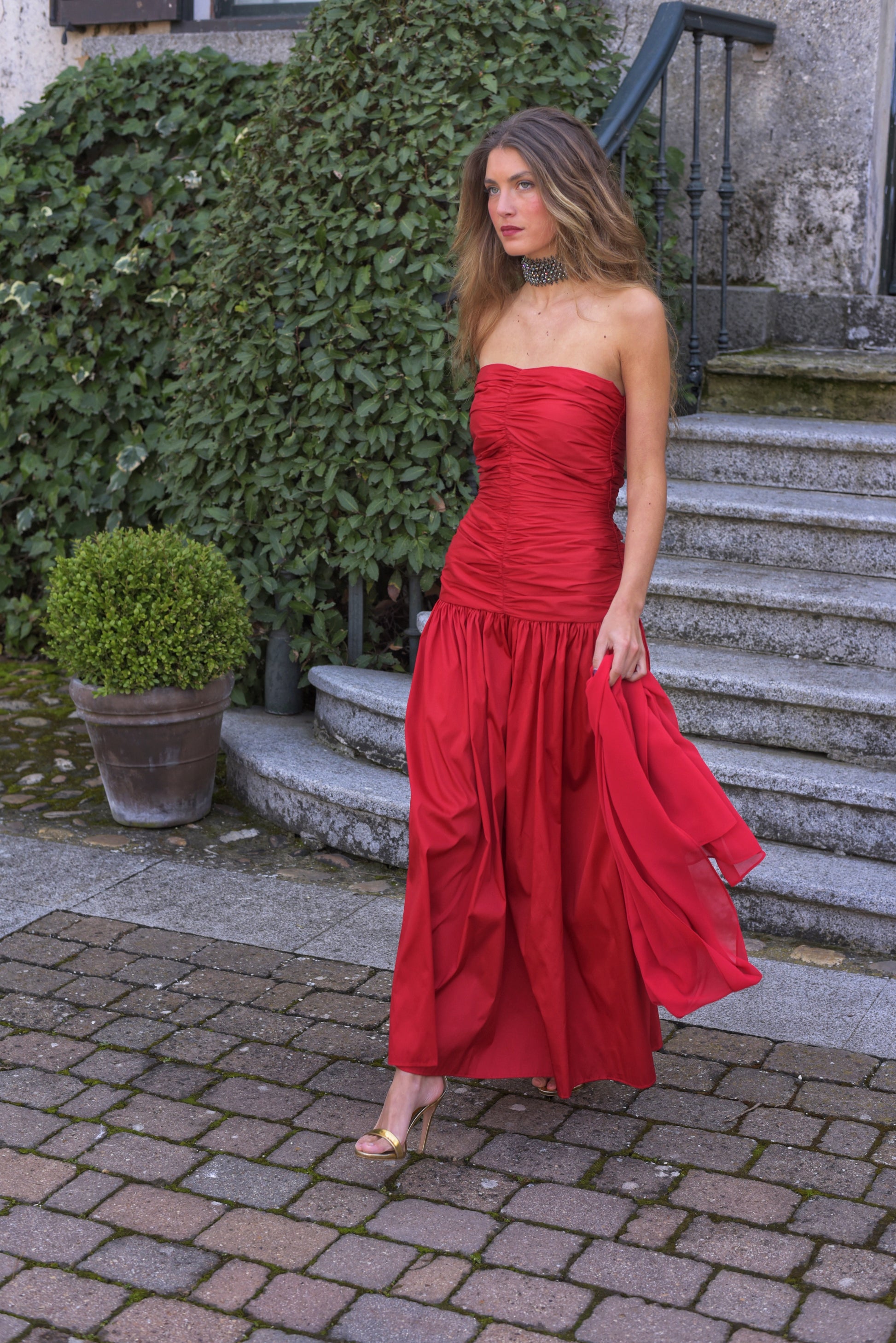 El Vestido Lady Pantera rojo es una elección atrevida y elegante para invitadas que buscan un look con presencia y movimiento. Diseñado con un escote palabra de honor y un cuerpo muy fruncido que realza el busto y la figura, este vestido largo de fiesta destaca por su falda abullonada desde la cadera, que aporta volumen y dramatismo con cada paso.

Confeccionado en tafeta de alta calidad en un impactante tono cardenal, incluye un fular de gasa a juego, perfecto para cubrir los hombros con ligereza o jugar c
